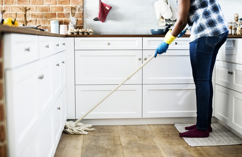 a lady mopping in a kitchen