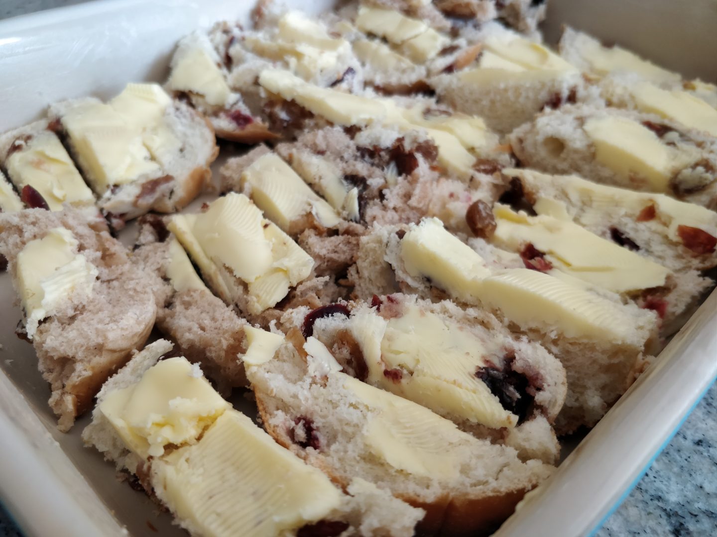 Preparing the layers of Hot Cross Bun and Butter Pudding