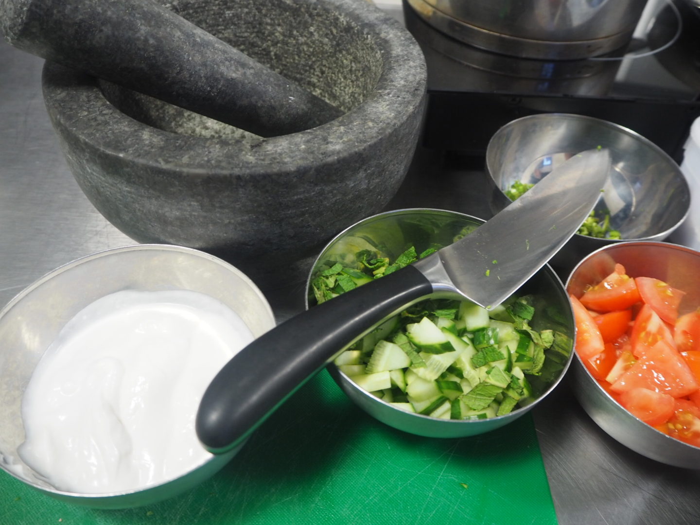 Bowls of prepared ingredients next to mortar and pestle